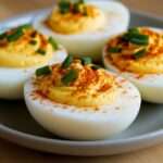 demi‑œufs farcis à la crème jaune, saupoudrés de paprika et ciboulette