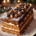 Bûche de Noël roulée au chocolat et noisettes décorée de ganache et sucre glace.