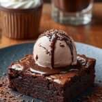 Brownie au chocolat fondant servi avec glace et sauce chocolat.