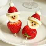 Brochettes en forme de Père Noël réalisées avec fraises, bananes et guimauves.
