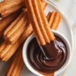 Churros dorés enrobés de sucre et cannelle avec sauce au chocolat.