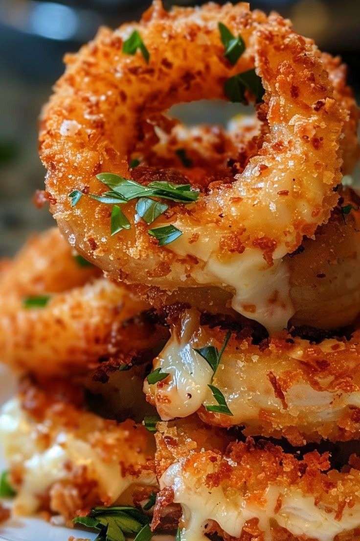 Rondelles d’oignon farcies à la mozzarella dorées et croustillantes, servies chaudes avec une sauce marinara.