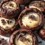 Biscuits au chocolat fourrés à la crème pâtissière, décorés de copeaux de chocolat noir et présentés sur une assiette.