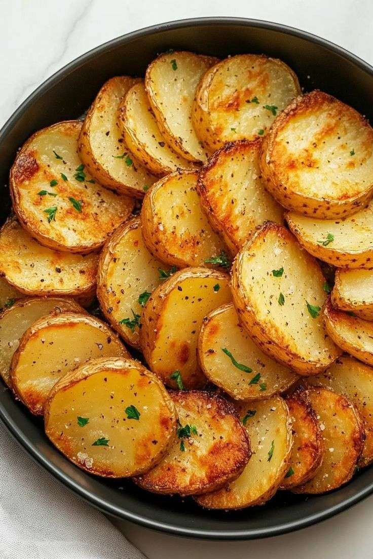 Pommes de terre rôties en rondelles dorées avec herbes et ail.
