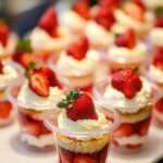 Verrines aux fraises et crème au mascarpone, garnies de fraises fraîches et de feuilles de menthe, servies bien fraîches.