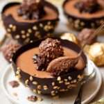 Bol en chocolat garni de mousse Ferrero Rocher et décoré de noisettes hachées.