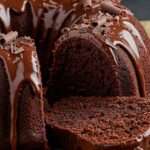 Bundt cake au chocolat nappé d’un glaçage brillant et décoré de copeaux de chocolat.