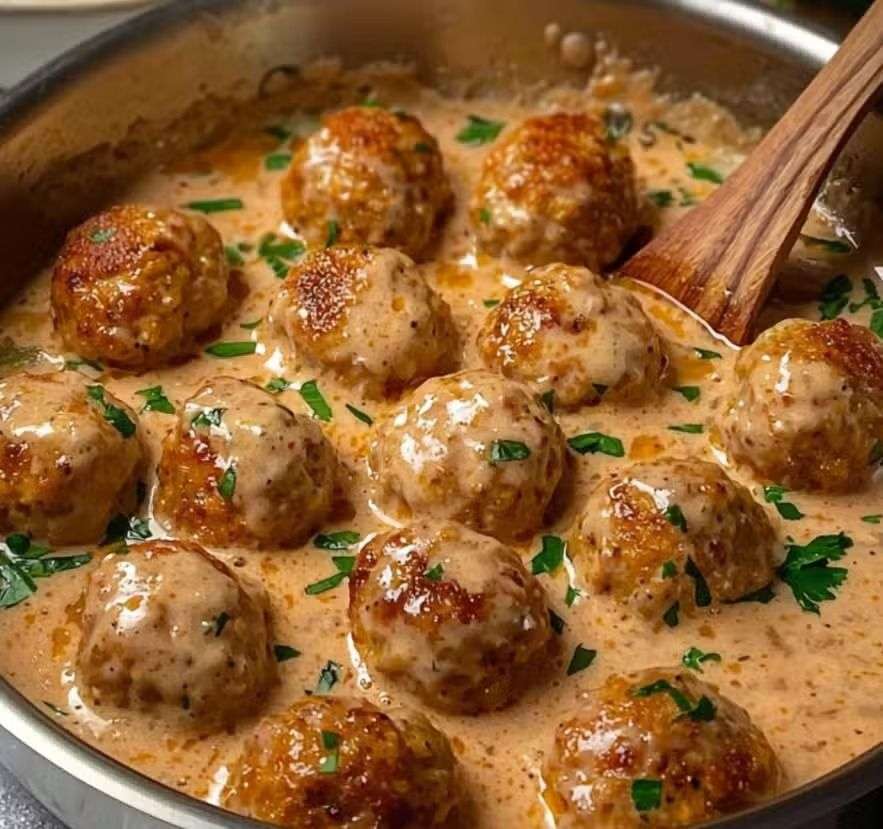 Assiette de boulettes de viande suédoises nappées de sauce crémeuse avec purée.