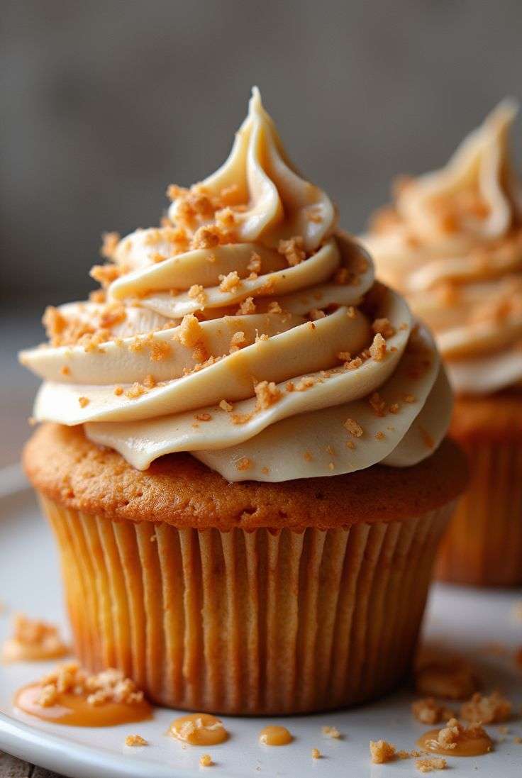Cupcakes Biscoff au spéculoos décorés d’un glaçage Biscoff tourbillonné et de miettes de biscuits.