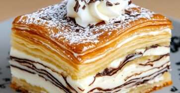 Millefeuille vanille maison composé de trois couches de pâte feuilletée et de crème diplomate onctueuse, saupoudré de sucre glace.