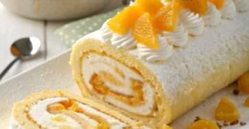 Gâteau roulé à la mangue garni d’une crème à la mangue et mascarpone, décoré de morceaux de mangue fraîche.