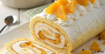 Gâteau roulé à la mangue garni d’une crème à la mangue et mascarpone, décoré de morceaux de mangue fraîche.