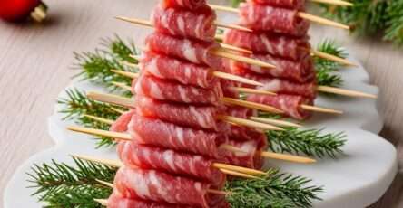 Brochettes en forme de sapins composées de tranches de saucisson pliées, décorées de romarin et d’une étoile comestible.