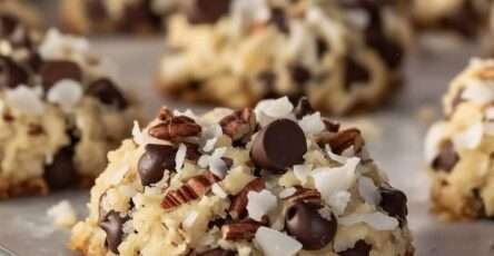 Biscuits de Noël moelleux à la noix de coco, chocolat et noix de pécan dorés sur une plaque.