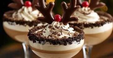 Coupes dessert au chocolat décorées en rennes de Noël avec crème fouettée, bois en chocolat et nez rouge.