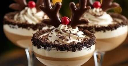 Coupes dessert au chocolat décorées en rennes de Noël avec crème fouettée, bois en chocolat et nez rouge.