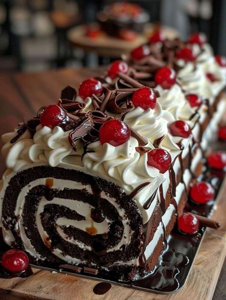 Bûche roulée Forêt-Noire au chocolat, crème mascarpone et cerises, façon gâteau roulé élégant avec copeaux de chocolat, sirop parfumé et décor aux cerises pour Noël.