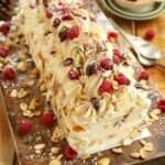Bûche roulée au mascarpone garnie de framboises fraîches et amandes effilées, saupoudrée de sucre glace.