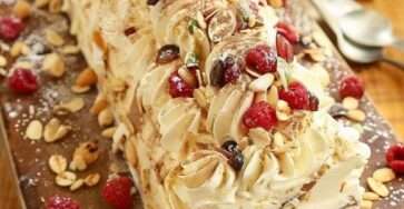 Bûche roulée au mascarpone garnie de framboises fraîches et amandes effilées, saupoudrée de sucre glace.