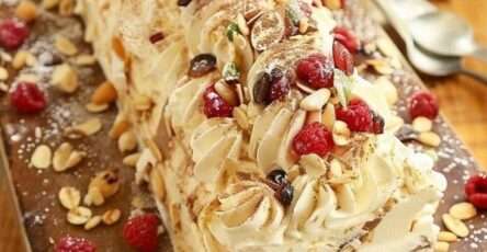 Bûche roulée au mascarpone garnie de framboises fraîches et amandes effilées, saupoudrée de sucre glace.