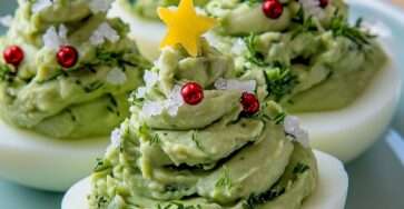 Œufs farcis garnis de guacamole en forme de sapins de Noël, décorés de perles rouges et d’étoiles de fromage.