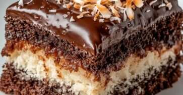 Gâteau marbré chocolat et noix de coco nappé d’un glaçage brillant et décoré de coco grillée.