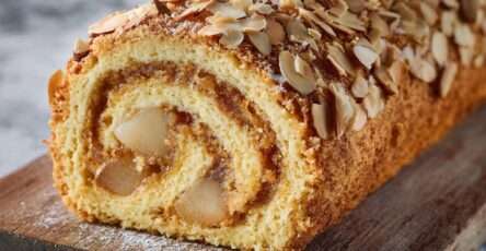 Roulé poire amande garni de crème mascarpone et décoré d’amandes effilées sur le dessus.