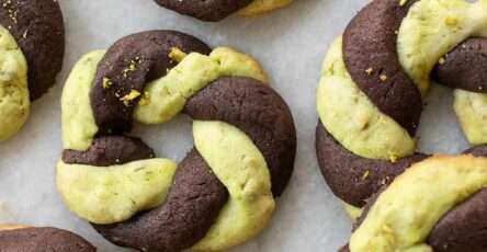 Cookies tressés bicolores chocolat pistache en forme de couronnes dorées et torsadées.