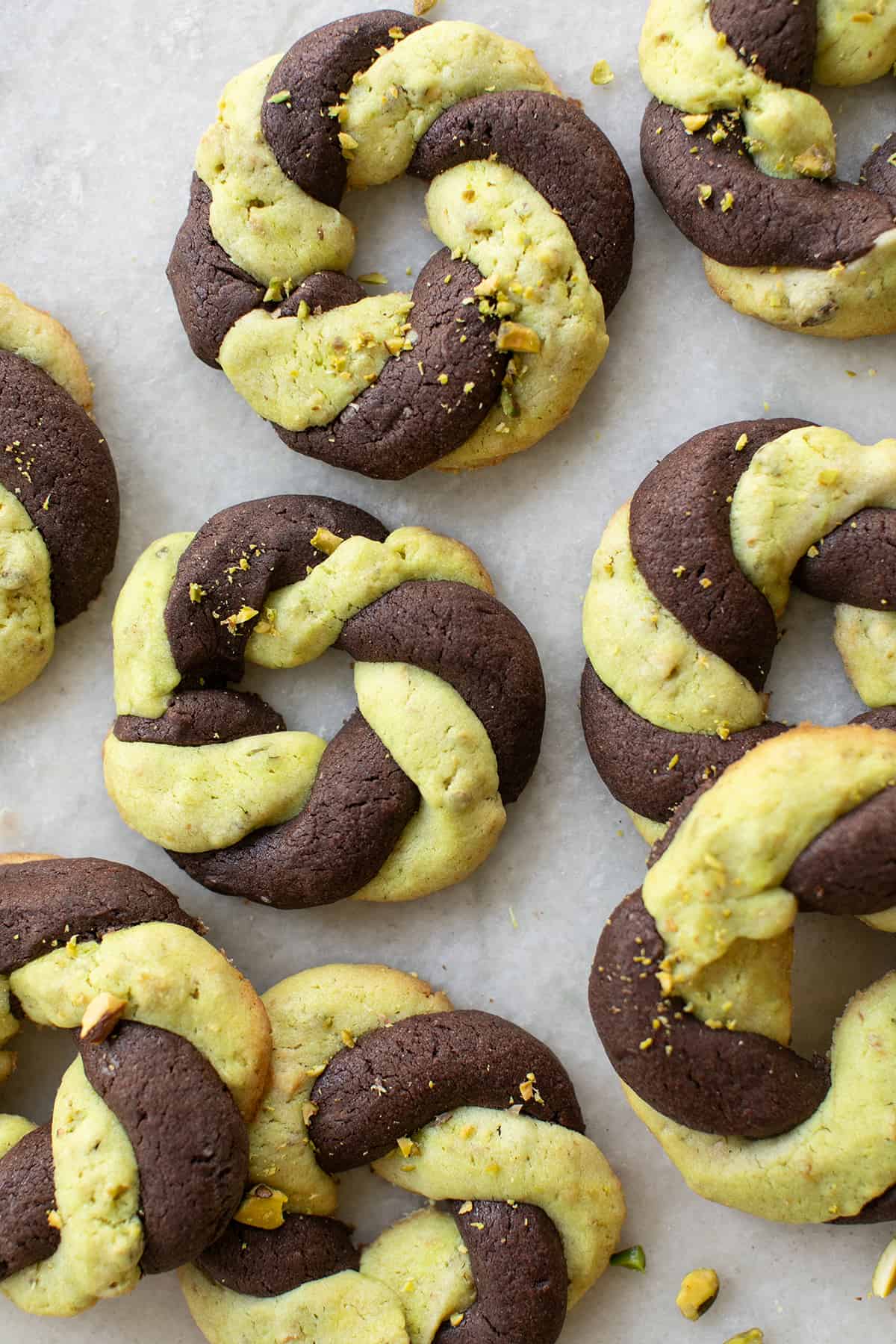 Cookies tressés bicolores chocolat pistache en forme de couronnes dorées et torsadées.