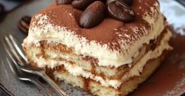 Tiramisu classique en couches avec cacao saupoudré, crème mascarpone et biscuits imbibés de café.