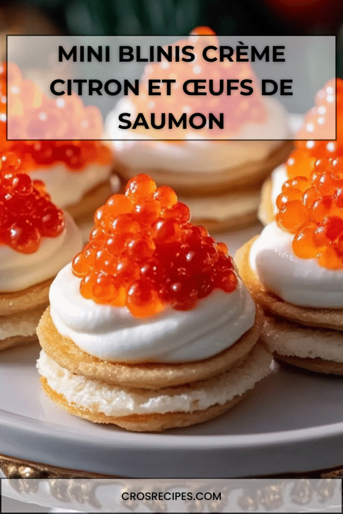 Mini blinis garnis de crème citronnée et surmontés d’œufs de saumon, présentés sur un plateau apéritif.