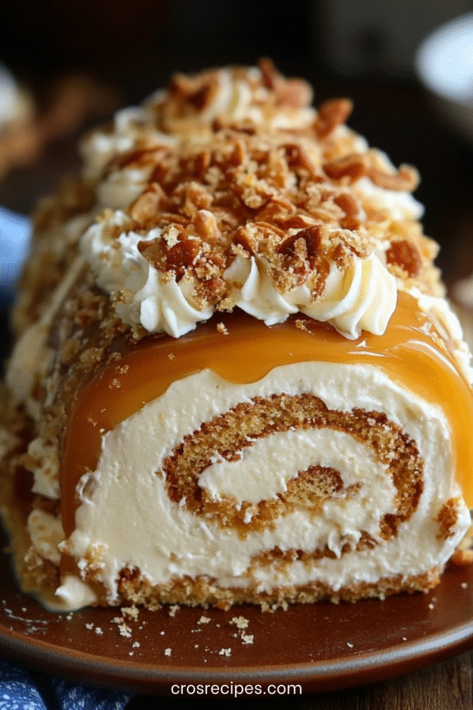 Gâteau roulé garni de crème au caramel beurre salé, décoré de caramel coulant et de noisettes concassées.