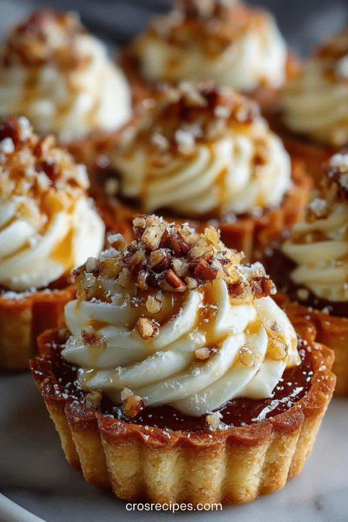 Mini tartelettes au fromage à la crème avec pacanes croquantes et filet de sirop d’érable.