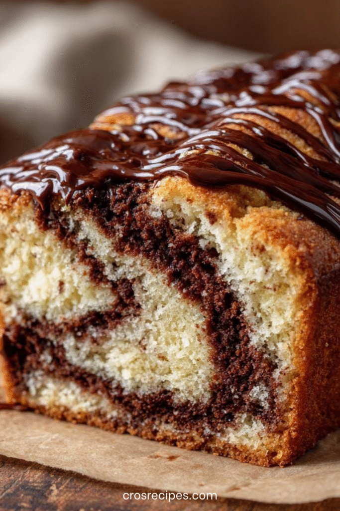 Cake marbré vanille-chocolat tranché avec glaçage fondant au chocolat coulant sur le dessus.