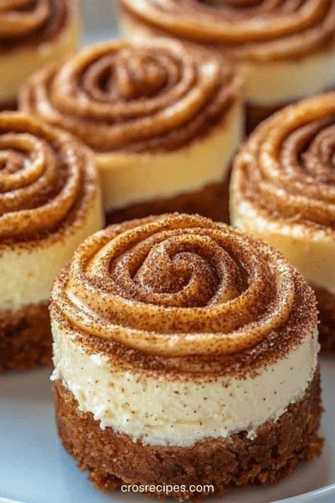 Mini cheesecakes roulés à la cannelle avec swirl façon cinnamon roll et glaçage crémeux.