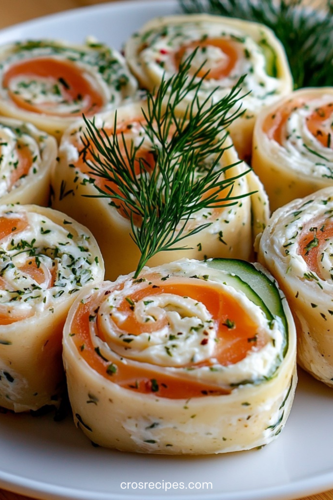 Roulés au saumon fumé et fromage frais aux herbes, coupés en spirales régulières et dressés sur un plateau festif.