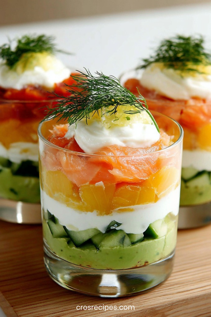 Verrines d’avocat crémeux, yaourt grec onctueux et saumon citronné, garnies d’aneth frais et de dés de concombre.