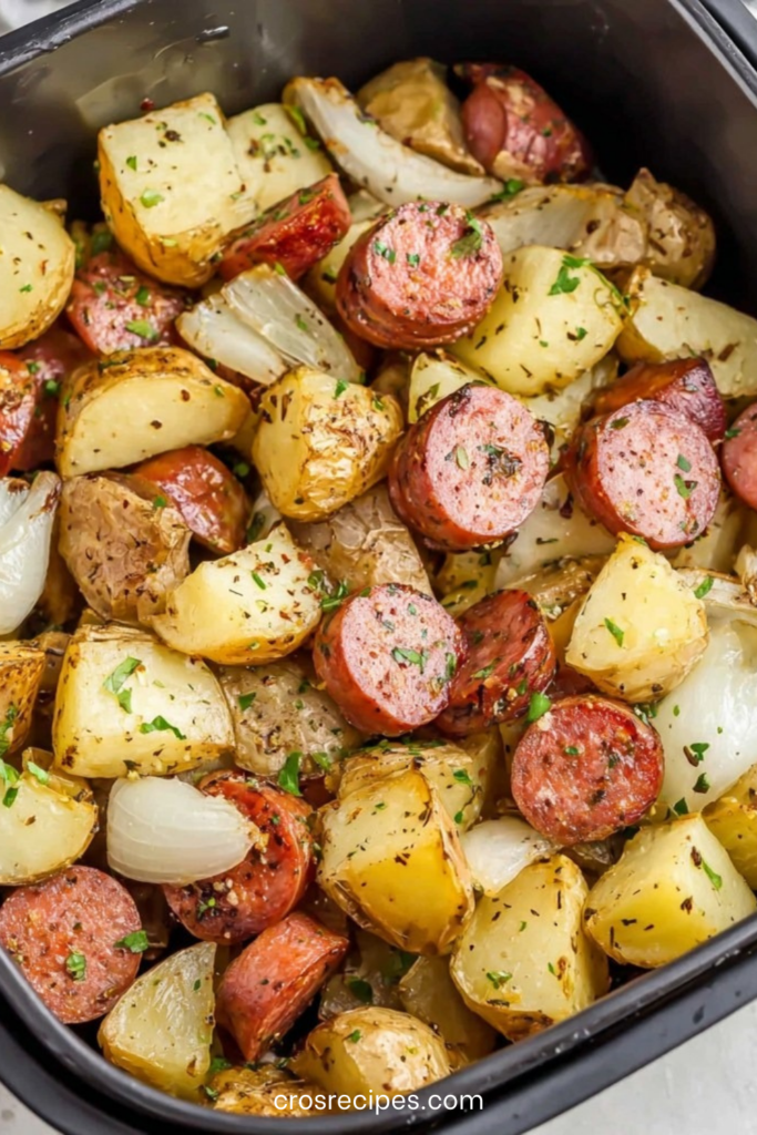 Plat familial de saucisses fumées en rondelles et pommes de terre grenaille rôties au four avec oignons caramélisés et persil frais ciselé