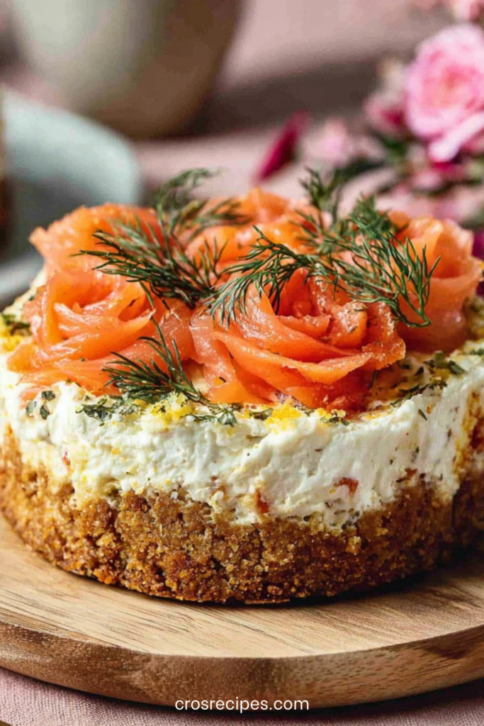 Mini cheesecake salés garnis de saumon fumé roulé en rosaces et d’aneth frais, présentés en petites portions individuelles sur une assiette