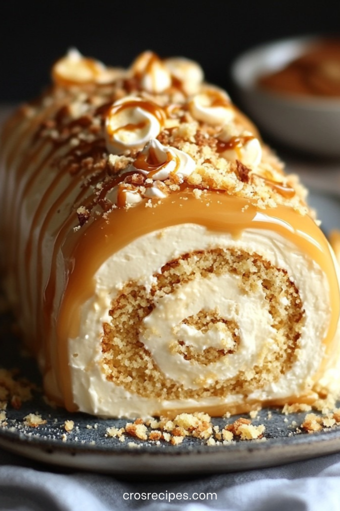 Gâteau roulé garni de crème au caramel beurre salé et mascarpone, nappé de caramel et décoré de noisettes concassées