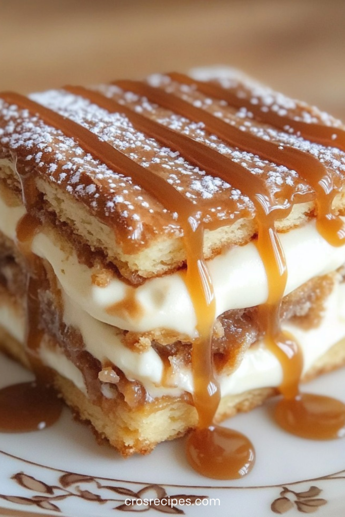Mille-feuille au caramel composé de couches de pâte feuilletée dorée et de crème caramel, nappé de caramel au beurre salé et saupoudré de sucre glace