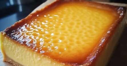 Tranche de flan pâtissier maison crémeux, épais et doré sur le dessus.