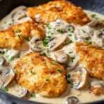 Poulet pané croustillant servi avec une sauce crémeuse aux champignons et parmesan.