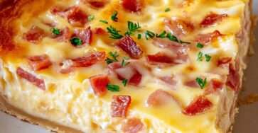 Quiche Lorraine dorée et fondante, coupée en parts, avec lardons et fromage dans une pâte croustillante.