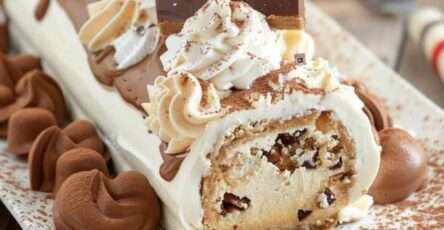 Bûche de Noël roulée au café, décorée de cacao et grains de café.