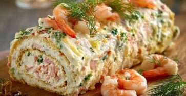 Bûche salée aux fruits de mer garnie de crevettes, saumon fumé et aneth, servie en entrée festive.