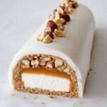 Bûche glacée vanille avec cœur caramel beurre salé et éclats de noisettes, servie en dessert festif.