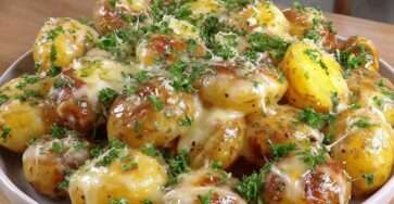 Pommes de terre grenailles dorées au beurre noisette, recouvertes de comté fondant et parsemées de persil frais.