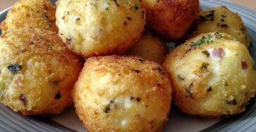 Boulettes de pommes de terre croustillantes dorées, garnies de fromage frais fondant, servies chaudes sur une assiette.