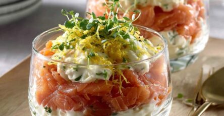 Verrines de saumon fumé au fromage frais citronné, décorées de micro-pousses, servies en entrée élégante.